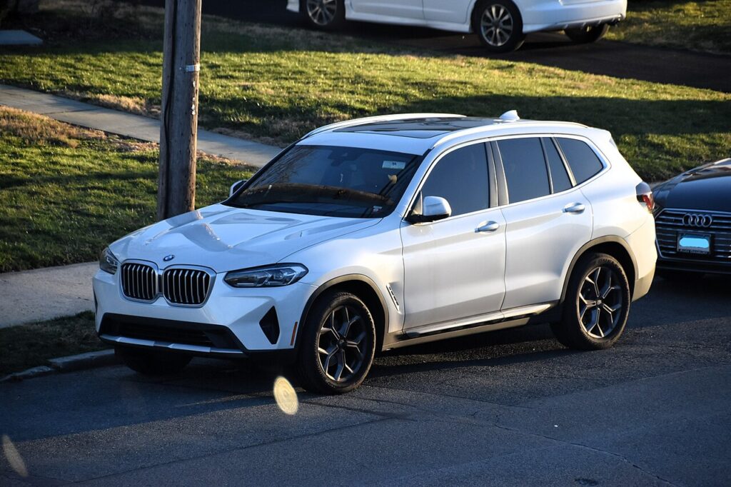 주택가 도로에 주차된 흰색 BMW X3의 전면과 측면