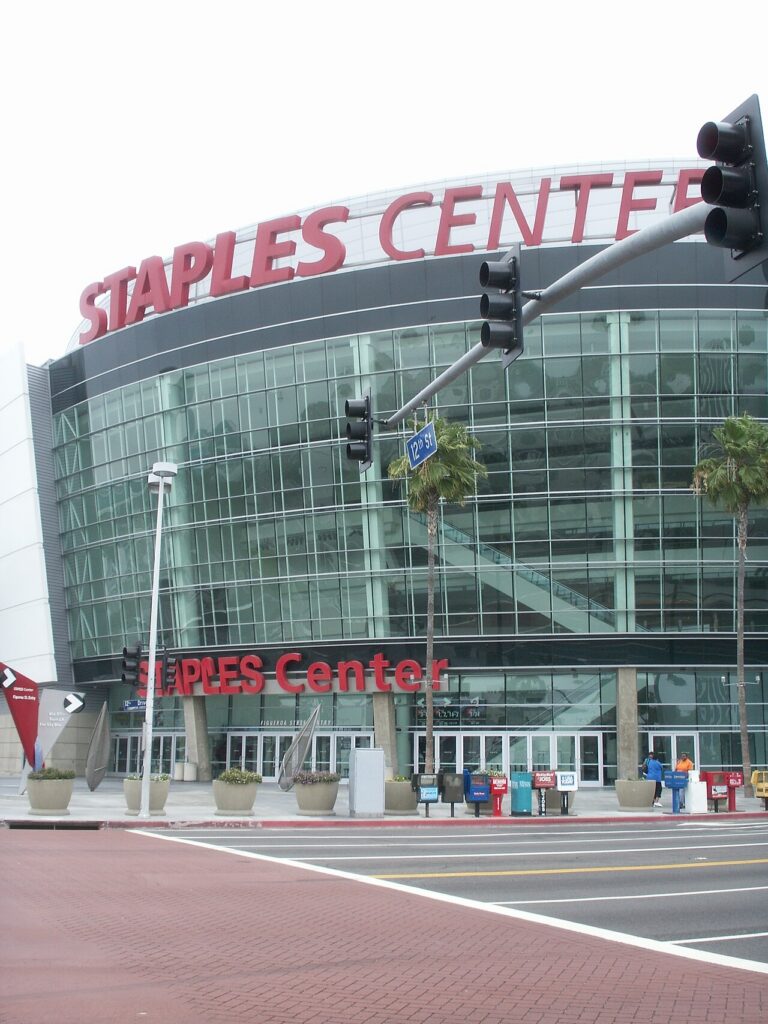 붉은 Staples Center 간판과 유리 외벽, 출입구가 보이는 로스앤젤레스 경기장 외관